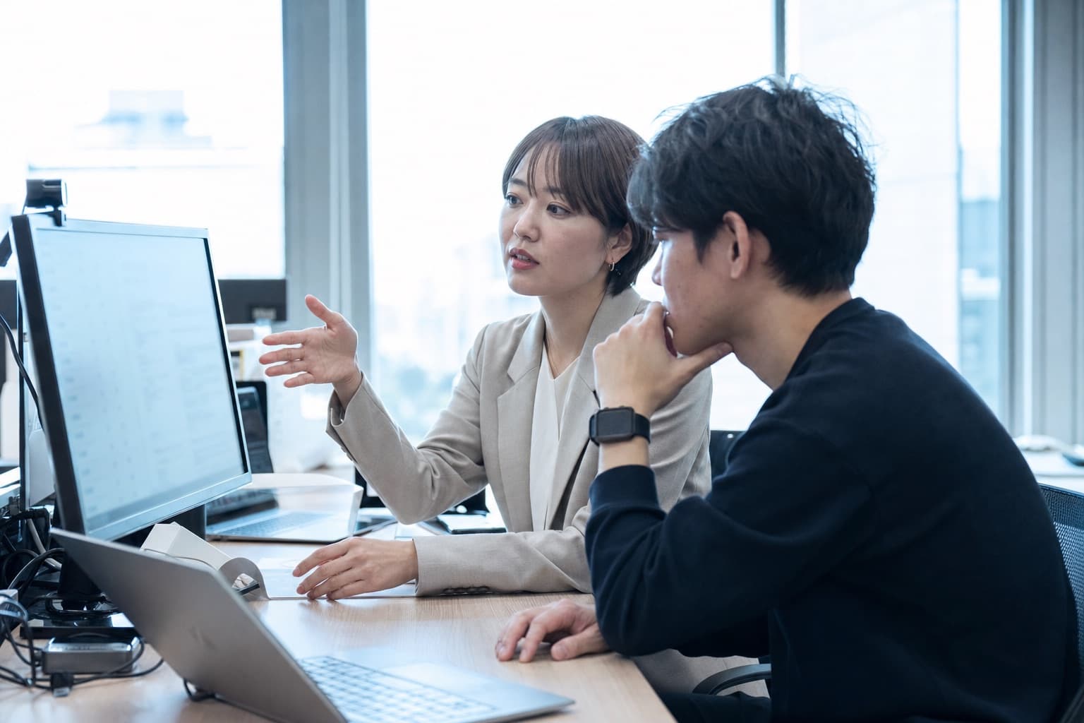 採用担当者とエンジニアが管理画面を見ながら議論している様子